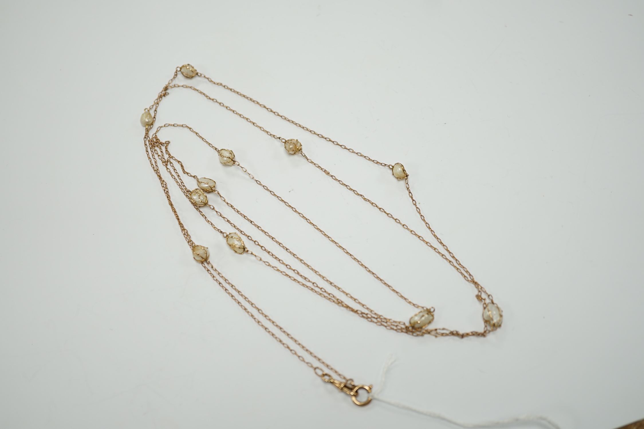 An early 20th century 9ct and eleven stone baroque pearl set long chain, 160cm, gross 13.2 grams.